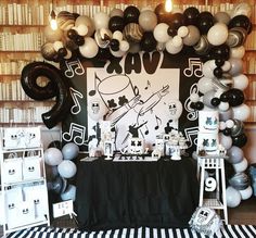 a black and white themed birthday party with balloons, music notes, and musical instruments