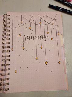 a spiral notebook with the word january written in cursive writing next to markers