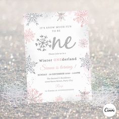 a white and pink snowflaked birthday party card with the words one written on it