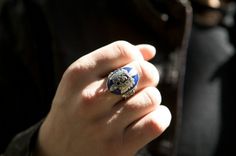 a person wearing a ring with a lion on it