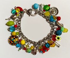 Colorful Handmade Charm Bracelet As Gift, Artistic Handmade Multicolor Beaded Bracelets, Artistic Multicolor Handmade Beaded Bracelets, Artistic Handmade Multicolor Bracelets, Vibrant Handcrafted Bracelets For Festivals, Handmade Multicolor Adjustable Charm Bracelet, Handmade Vibrant Bracelets For Festivals, Vibrant Red Bracelets For Gift, Artistic Multicolor Beach Jewelry