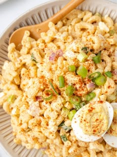 a bowl filled with macaroni salad and an egg