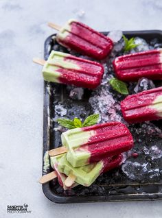 several popsicles are on a tray with ice and garnishes in them