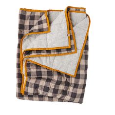 the black and white checkered blanket is folded on top of each other, with yellow trim