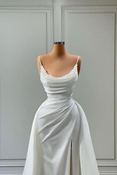 a white dress on display in front of a mannequin's headdress