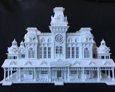 a white model of a building with a clock on it