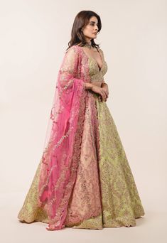 Editor's Note Lime Green Tafetta Lehenga Choli With A Soft Pink Tulle Dupatta Embellished With Gota, Beads, Pearls Sequins And Fuschia Resham French Knots. Color: Green Fabric: Tulle, Tafetta Care: Dry Clean Only About the Designer Nitika Gujral’s journey with designing clothes started almost four decades back while she was still in high school and held her first exhibition for family and friends. Making clothes has been a part of her life ever since. Pista Green Lehenga Combination, Pink And Green Lehenga, Pink Indian Suit, Lime Green Lehenga, Pink Indian Wedding, Simple Lehenga Choli, Lengha Design, Green Lehenga Choli, Yellow Color Combinations