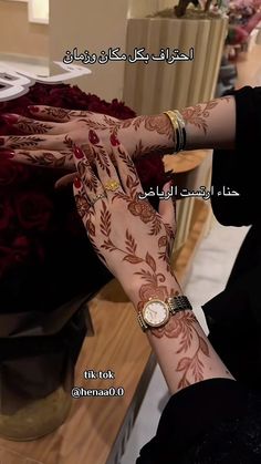 a woman with henna on her arm and wrist is touching the hand of another woman