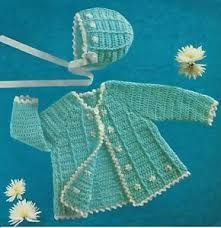 a crocheted baby's cardigan and bonnet with flowers