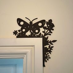 a metal butterfly on the wall above a mirror