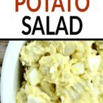 a white bowl filled with mashed potatoes on top of a wooden table next to a sign that says potato salad