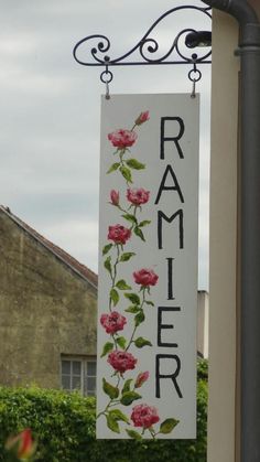 a sign hanging from the side of a building that says rammer with flowers painted on it