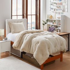 a bed sitting in a bedroom next to a window