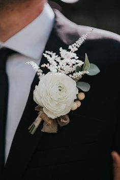 a man in a suit and tie with a boutonniere on his lapel