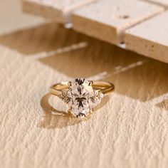 a diamond ring sitting on top of a piece of paper next to an object that is laying on the ground