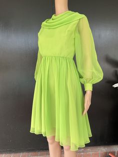 "1960s dress. Green polyester chiffon. Acetate lined bodice and skirt. Sheer sleeves with two snap fasteners on each cuff. Draped collar. Skirt gathered at waist. Nylon zip back. Measurements are 30\" bust 22\" waist Free hips 14\" bodice length 35\" length 22\" sleeves 13\" back shoulders (between sleeve seams) Pretty dress shows well, displaying very minimal to no obvious wear. Hand washable or dry clean." Vintage Green Long Sleeve Mini Dress, Green Long Sleeve Lined Dress, Green Lined Vintage Dress, Green Retro Cocktail Dress, Green Fitted Vintage Mini Dress, Green Vintage Dress For Evening, Green Retro Evening Dress, Retro Green Evening Dress, Green Vintage Mini Dress For Party