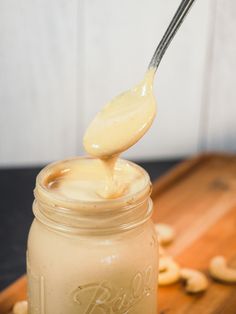 a spoon full of peanut butter on top of a jar