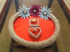 an elaborately decorated cake on display in a glass case with red cloth and flowers