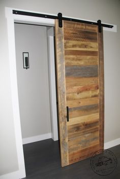 an open wooden door sitting inside of a white walled room on top of a hard wood floor