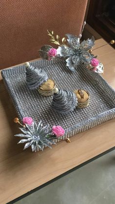 three cupcakes are sitting on a tray decorated with flowers and pineapples