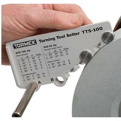 a person is holding a tool setter in their left hand and pointing at it