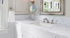 a bathroom with two sinks and a large mirror above the sink is in front of a window