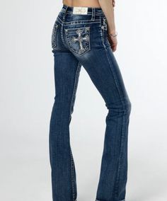 The Miss Me Women's Scalloped Edge Cross Embroidered Mid-Rise Bootcut Jeans feature a medium dark-wash and a mid-rise fit. They are adorned with white, silver, and blue embroidery, as well as mini rhinestone and translucent sequin details. The jeans also include a white leather logo brand patch and rhinestone rivets for added style. 5-pocket design Slight distressing on back pocket and front belt loop area Slight Fading Front Rise: 9.5" Back Rise: 14" Inseam: 34" 52% Cotton 27% Lyocell 20% Polyester 1% Elastane Gentle machine wash with like colors in cold water Tumble dry low Store Stand, Mid Rise Bootcut Jeans, Western Store, Cowgirl Western, Blue Embroidery, Western Hats, Leather Logo, Scalloped Edge, Miss Me