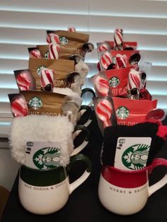 two starbucks mugs with candy canes in them