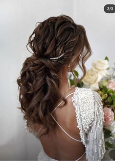 the back of a woman's head with long hair and pearls in her hair