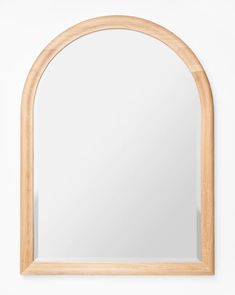 an arched wooden mirror hanging on the wall