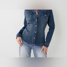 The Western Denim Shirt Is A True Classic. This Long Sleeve Women's Denim Shirt Features A Classic Collared, Button Down Design. Finished With A Western Style Yoke, Pearlized Snaps, And Chest Patch Pockets With Our Signature Horseshoe Stitching. Dark Wash Denim Shirt With Button Closure, Fitted Denim Shirt With Button Closure, Denim Blue Button-up Top With Snap Buttons, Denim Button-up Top With Snap Buttons, Button-up Denim Tops With Snap Buttons, Medium Wash Denim Shirt With Snap Buttons, Fitted Button-up Denim Top, Dark Wash Denim Button-up Top With Snap Buttons, Fitted Dark Wash Denim Button-up Top