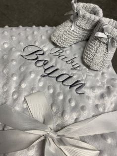 a white blanket with baby booties on it