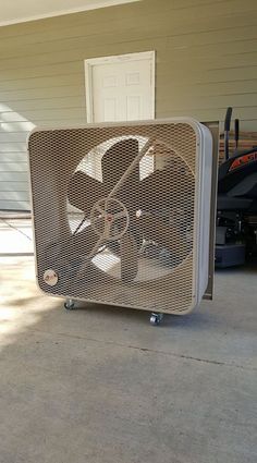 an old air conditioner sitting on top of a sidewalk next to a garage door