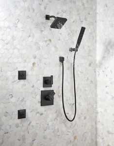 the shower head and handset are connected to the wall with water running from it