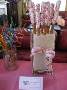 there are candy sticks in a vase on the table