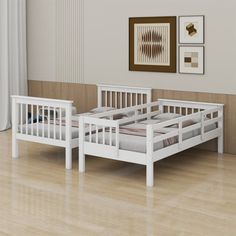 two white beds sitting next to each other on top of a hard wood floored floor