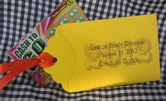 a yellow envelope with an orange ribbon tied around it and some candy on the table