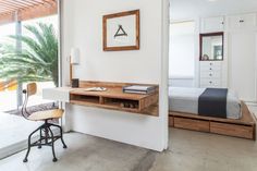 a room with a bed, desk and chair next to a sliding glass door that opens onto a patio