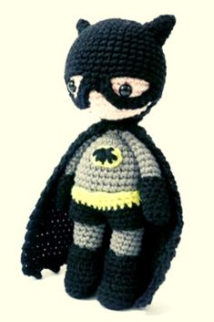 a crocheted batman doll is posed on a white background