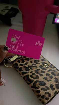 a person holding up a pink card with writing on it