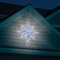 a lighted star on the side of a house