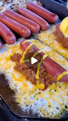 hotdogs with mustard and ketchup are on a baking sheet