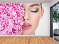 a woman's face with pink flowers on the wall behind her, in an empty room