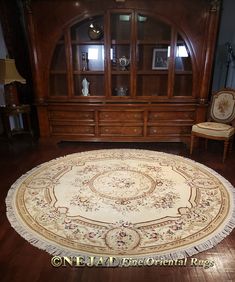 a living room with a large rug on the floor next to a chair and bookcase