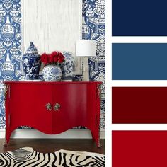 a red cabinet with blue and white wallpaper next to a zebra print area rug