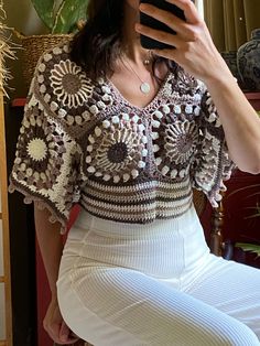 a woman is taking a selfie with her cell phone while sitting on a chair