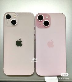 two pink iphones sitting side by side next to each other