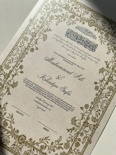 an ornate wedding card in gold and white with arabic calligraphy on the front cover