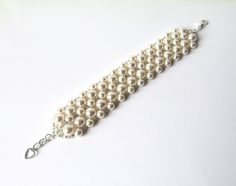 A timeless bracelet completely hand-woven in your choice of Swarovski white (shown in pictures) or ivory/cream pearls and tiny antique silver Japanese seed beads. ~1/2 INCH EXTENSION INCLUDED ~ For adjustable sizing, embellished with silver heart charm~Width Approximately 1.25 inches~♥ All jewelry comes in a gift box and is ready to give, at no additional cost! ♥------::BRACELET SIZE::X Small - 6.5" ~ expands toSmall - 7" ~ expands to 7.5"Standard - 7.5" ~ expands to 8"Large - 8" ~ expands to 8. Cream Wedding Bracelet Jewelry, Adjustable Cream Bracelet For Wedding, Adjustable Cream Bracelet For Weddings, Cream Beaded Bracelets For Wedding, Cream Pearl Bracelet With Round Beads For Wedding, Elegant Adjustable Cream Pearl Bracelet, Elegant Beaded Cream Bracelets, Elegant Cream Pearl Bracelet For Wedding, Formal White Adjustable Beaded Bracelets