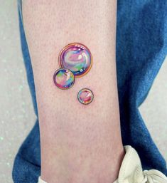 a woman's foot with two soap bubbles on her left ankle and the word love written in it